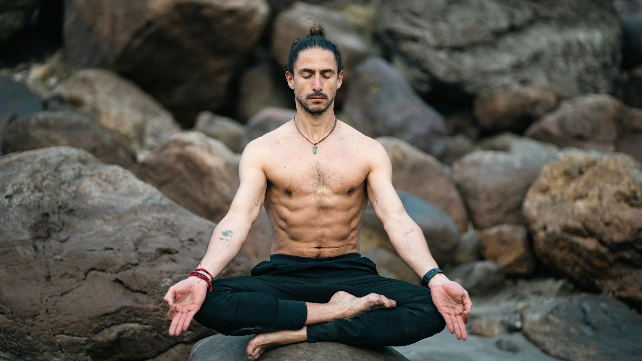 Man meditating on rocks