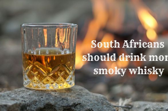 Glass of smoky whisky with a fire background